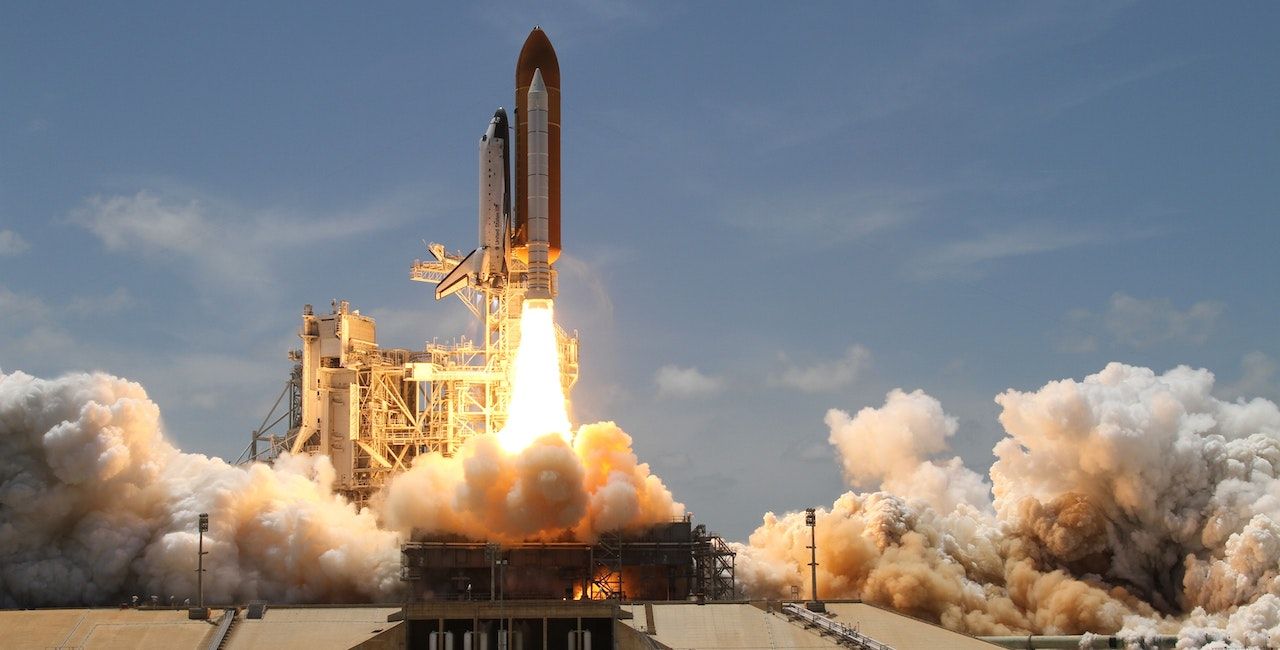 A photo of a rocket taking off with a space shuttle.
