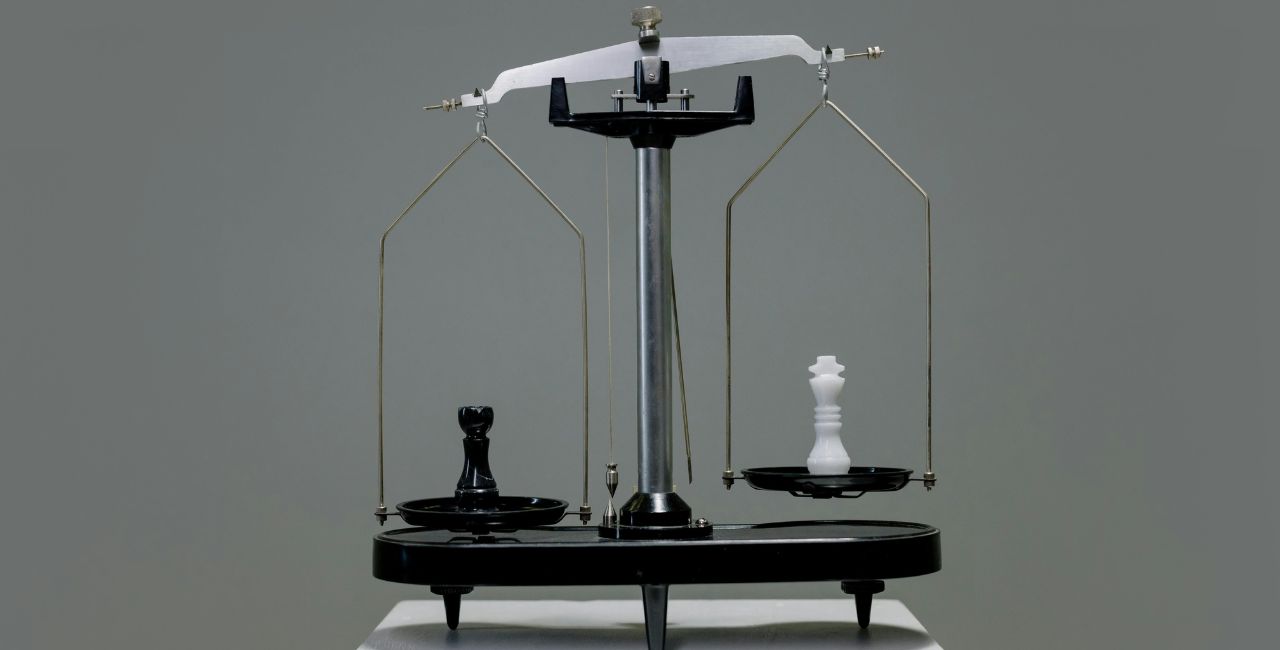 A scale with a black and a white chess piece.