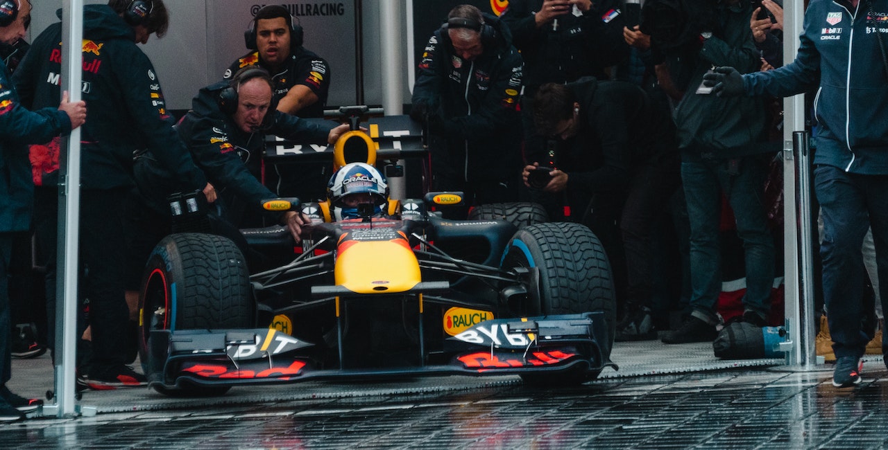 Photo of a Formula 1 racing car coming out of the pit stops.